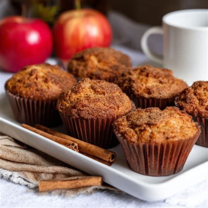 Apple cinnamon muffins in a white muffin baking dish.