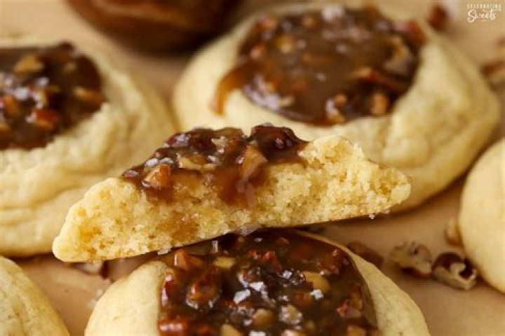 Pecan pie cookie broken in half sitting on top of another pecan pie cookie.