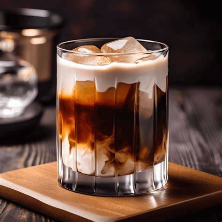 White Russian in a glass with a small gold spoon.
